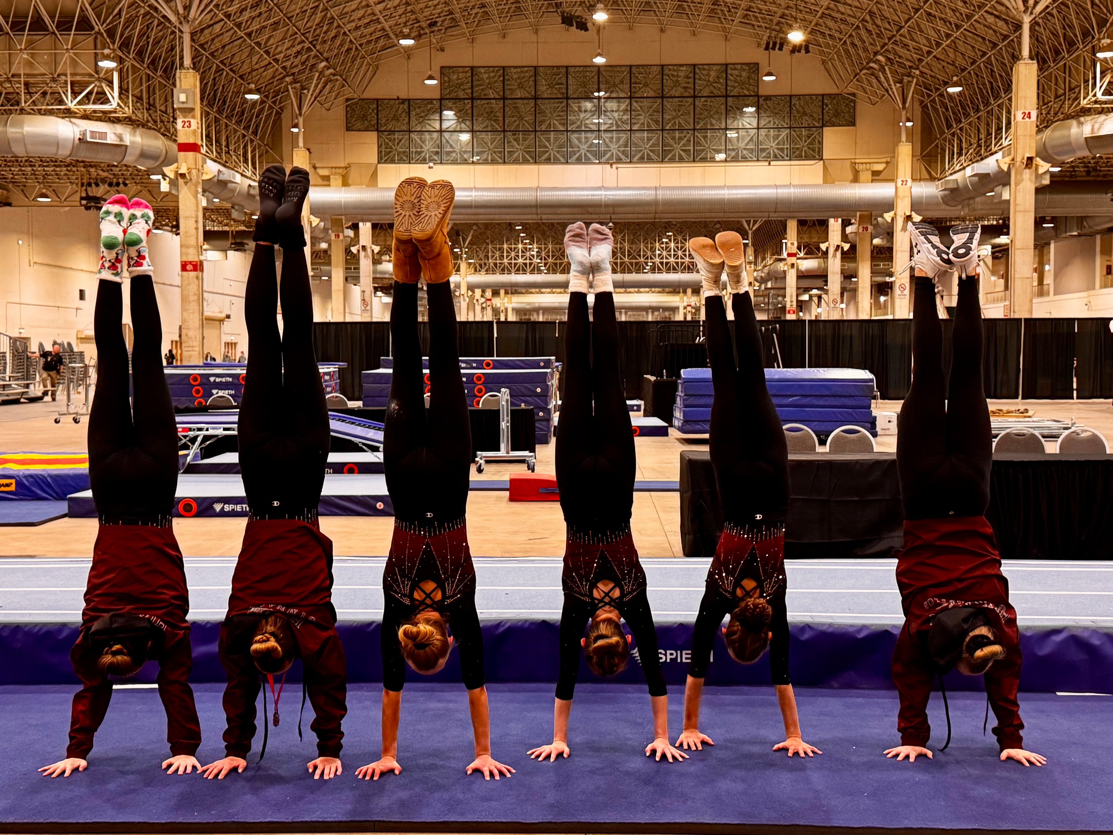 Team performing synchronized handstands at a competition venue